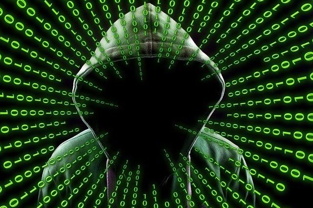 hacker-2883632_640 In grünlichem Ton gehaltenes Bild eines mit Kaputze anonymisierten Hackers